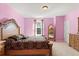 Bedroom with pink walls, a window, and a decorative wood framed bed at 3868 Whitewood Ct, Oviedo, FL 32766