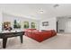 Entertainment space with a large red sectional, arcade game and wall mounted television at 3868 Whitewood Ct, Oviedo, FL 32766