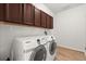 Laundry room with side by side washer and dryer and upper cabinets at 3868 Whitewood Ct, Oviedo, FL 32766