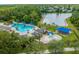 Aerial view featuring a pool, splash pad, restrooms and surrounding landscape, backing onto a lake at 3868 Whitewood Ct, Oviedo, FL 32766