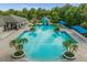 An aerial view of a bright blue swimming pool with a water slide and lounge chairs surrounded by trees at 3868 Whitewood Ct, Oviedo, FL 32766