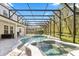 Gorgeous screened-in pool and spa area with outdoor seating and lush landscaping at 3868 Whitewood Ct, Oviedo, FL 32766