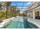Sparkling in-ground pool with spa in screened enclosure, surrounded by lush greenery at 3868 Whitewood Ct, Oviedo, FL 32766