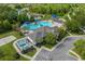 Aerial shot of pool, volleyball court, pool house, lounge chairs, and parking area with greenery around at 3868 Whitewood Ct, Oviedo, FL 32766