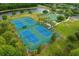 An aerial shot of tennis and basketball courts surrounded by a lake and trees in a residential area at 3868 Whitewood Ct, Oviedo, FL 32766
