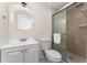 Bright bathroom featuring a modern vanity, round mirror, and glass-enclosed shower at 415 S Lancelot Ave, Orlando, FL 32835