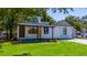 Charming home with a covered front porch, complemented by a green lawn and mature shade trees at 415 S Lancelot Ave, Orlando, FL 32835