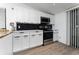 Modern kitchen featuring stainless steel appliances, white cabinets, and a stylish black backsplash at 415 S Lancelot Ave, Orlando, FL 32835