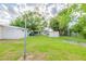 This backyard has a mix of green grass, mature trees, and utility structures at 4267 Kirkland Blvd, Orlando, FL 32811
