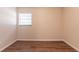 Bedroom features wood-look flooring and a window with mini blinds at 4267 Kirkland Blvd, Orlando, FL 32811