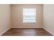 Bedroom features wood-look flooring, a window with mini blinds, and neutral walls at 4267 Kirkland Blvd, Orlando, FL 32811