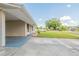 Wide view of the home's front, showcasing the extended covered parking, green lawn, and neighborhood street at 4267 Kirkland Blvd, Orlando, FL 32811