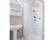 Bathroom with a pedestal sink, mirrored medicine cabinet, and shower with built-in shelving at 437 Bridgewater Court, Kissimmee, FL 34758