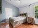 Well-lit bedroom features a rustic wood bed frame with storage, complemented by hardwood floors at 437 Bridgewater Court, Kissimmee, FL 34758