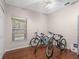 Spare bedroom featuring hardwood floors, a window, and multiple bicycles at 437 Bridgewater Court, Kissimmee, FL 34758