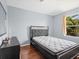 Cozy bedroom featuring a decorative headboard, hardwood floors, and natural light from the window at 437 Bridgewater Court, Kissimmee, FL 34758