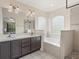Serene bathroom features dual sinks, a soaking tub, and a separate shower for a spa-like experience at 437 Bridgewater Court, Kissimmee, FL 34758