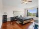 Bright bedroom with hardwood floors, a large window with outdoor views, and a statement headboard at 437 Bridgewater Court, Kissimmee, FL 34758