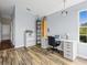 Bright home office featuring hardwood floors, a large desk, shelves, and a window with a view at 437 Bridgewater Court, Kissimmee, FL 34758
