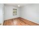 Bright bedroom showcasing wood-look floors, light walls, a window and a ceiling fan at 450 S Buena Vista Ave, Orlando, FL 32835