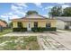 Charming single-story home with a yellow exterior, well-maintained lawn, and inviting entrance at 450 S Buena Vista Ave, Orlando, FL 32835