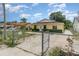 View of a yellow single-story home with a fenced front yard and driveway leading to the house at 450 S Buena Vista Ave, Orlando, FL 32835
