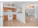 Bright kitchen featuring oak cabinets, white appliances, and tile flooring at 450 S Buena Vista Ave, Orlando, FL 32835