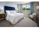 Serene main bedroom with a blue accent wall, plush carpet, and natural light streaming through the windows at 4543 Windy Oak Way, St Cloud, FL 34772