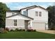 Charming two-story home with gray siding, stone accents, manicured lawn, and an attached two-car garage at 4549 Windy Oak Way, St Cloud, FL 34772