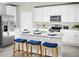 Bright kitchen with stainless steel appliances, white cabinetry, a large island with seating, and grey tile floors at 4549 Windy Oak Way, St Cloud, FL 34772