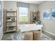 Home office with a modern white desk, decorative shelving, and a window offering a peaceful view at 4549 Windy Oak Way, St Cloud, FL 34772