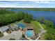 Aerial view showcases community amenities, a tennis court, a pool, and waterfront access offering a resort-style living at 468 Jaybee Ave, Davenport, FL 33897