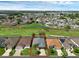 Expansive aerial view of a community featuring well-maintained homes and lush green spaces with a pond at 468 Jaybee Ave, Davenport, FL 33897