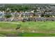 Scenic aerial view of a residential area with homes backing onto green spaces, and a lush tree line in the distance at 468 Jaybee Ave, Davenport, FL 33897