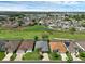 Expansive aerial view of a community featuring well-maintained homes and lush green spaces with a pond at 468 Jaybee Ave, Davenport, FL 33897