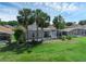 This home boasts a screened lanai, mature palm trees, and lush landscaping in a backyard setting at 468 Jaybee Ave, Davenport, FL 33897