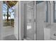 Well lit bathroom with glass shower and a door to an outdoor lanai and pool area at 468 Jaybee Ave, Davenport, FL 33897