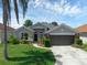 Charming one-story home boasts a manicured lawn, a two car garage, and beautiful landscaping at 468 Jaybee Ave, Davenport, FL 33897