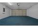 Spacious garage featuring a blue floor, white walls, and an insulated garage door at 468 Jaybee Ave, Davenport, FL 33897