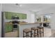 Bright kitchen featuring stainless appliances, green cabinetry and a breakfast bar with three stools at 468 Jaybee Ave, Davenport, FL 33897