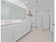 Bright bathroom with double sinks, quartz countertops and a glass enclosed shower at 4990 Four Strand Ct, St Cloud, FL 34769