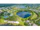 Community aerial showcasing a large lake surrounded by lush greenery, community amenities, and residential homes at 5032 Beach River Rd, Windermere, FL 34786