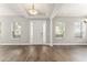 Bright and open foyer featuring wood-look floors, high ceiling, and white columns and trim at 5032 Beach River Rd, Windermere, FL 34786