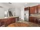 Kitchen with granite counters, stainless appliances, wood cabinets, and a wine rack above the refrigerator at 5032 Beach River Rd, Windermere, FL 34786