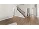 Open living room featuring hardwood floors, staircase with iron spindles and easy access to half bath at 5032 Beach River Rd, Windermere, FL 34786