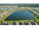 Expansive aerial view of a community featuring a large lake, meticulously landscaped lawns, and well-maintained homes at 5306 Rochester Pl, St Cloud, FL 34771