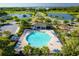 Aerial view of community pool, clubhouse, playground, and lush landscaping near lake at 5306 Rochester Pl, St Cloud, FL 34771
