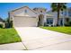 Charming home with a spacious two-car garage, lush lawn, and a beautifully landscaped yard at 5306 Rochester Pl, St Cloud, FL 34771