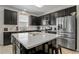 Modern kitchen with stainless steel appliances, dark cabinets, and a large island at 5306 Rochester Pl, St Cloud, FL 34771
