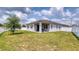 Large backyard featuring lush green grass, a white fence, a covered patio, and a barbecue grill at 600 Buchannan Dr, Davenport, FL 33837